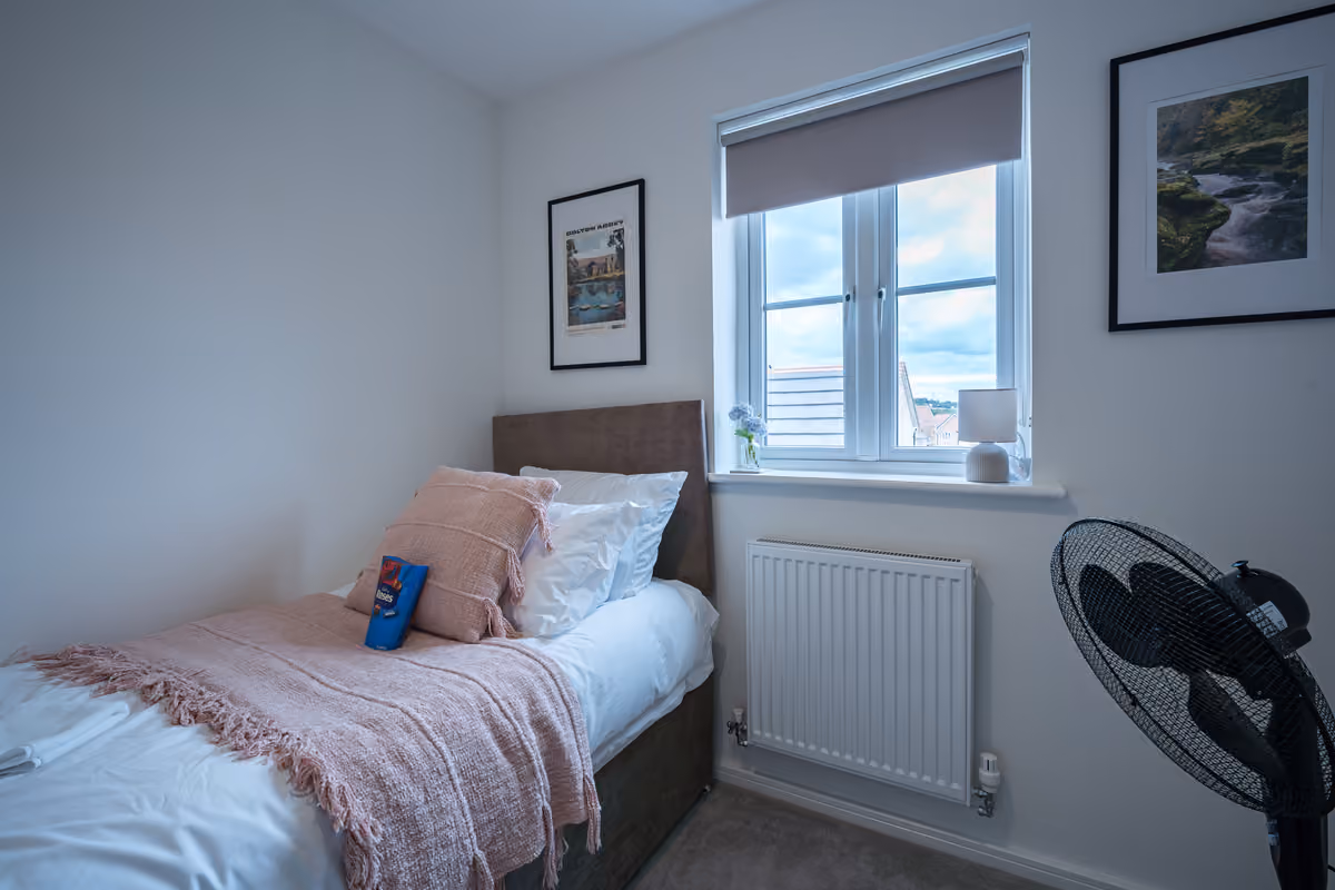 Single bedroom with radiator and fan