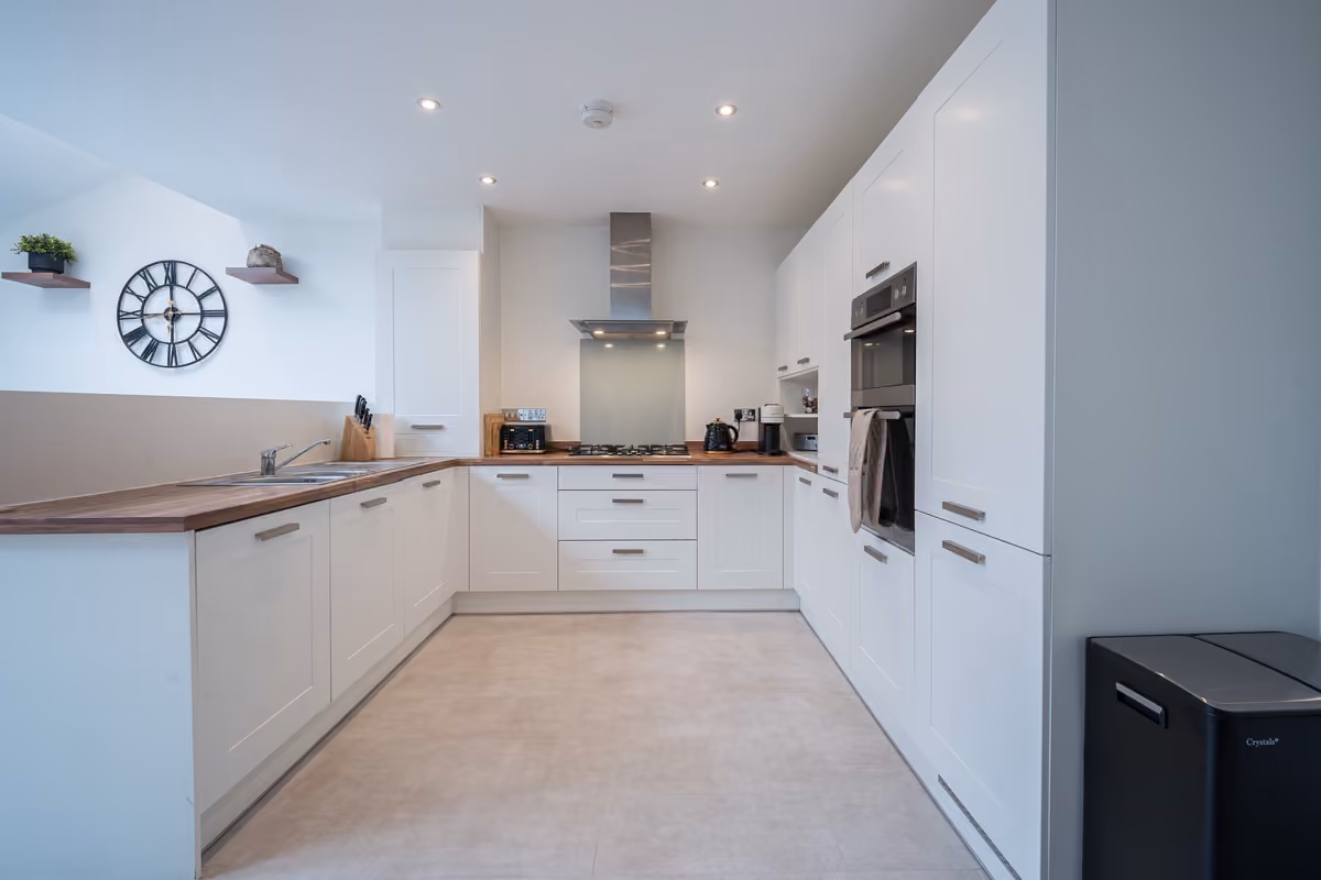 White kitchen with wood worktops and integrated appliances