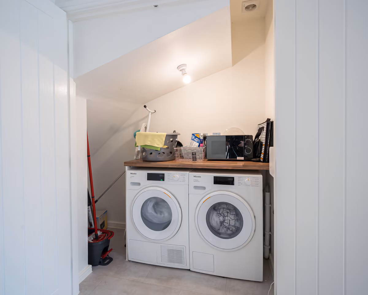 Utility area with washing machine and tumble dryer